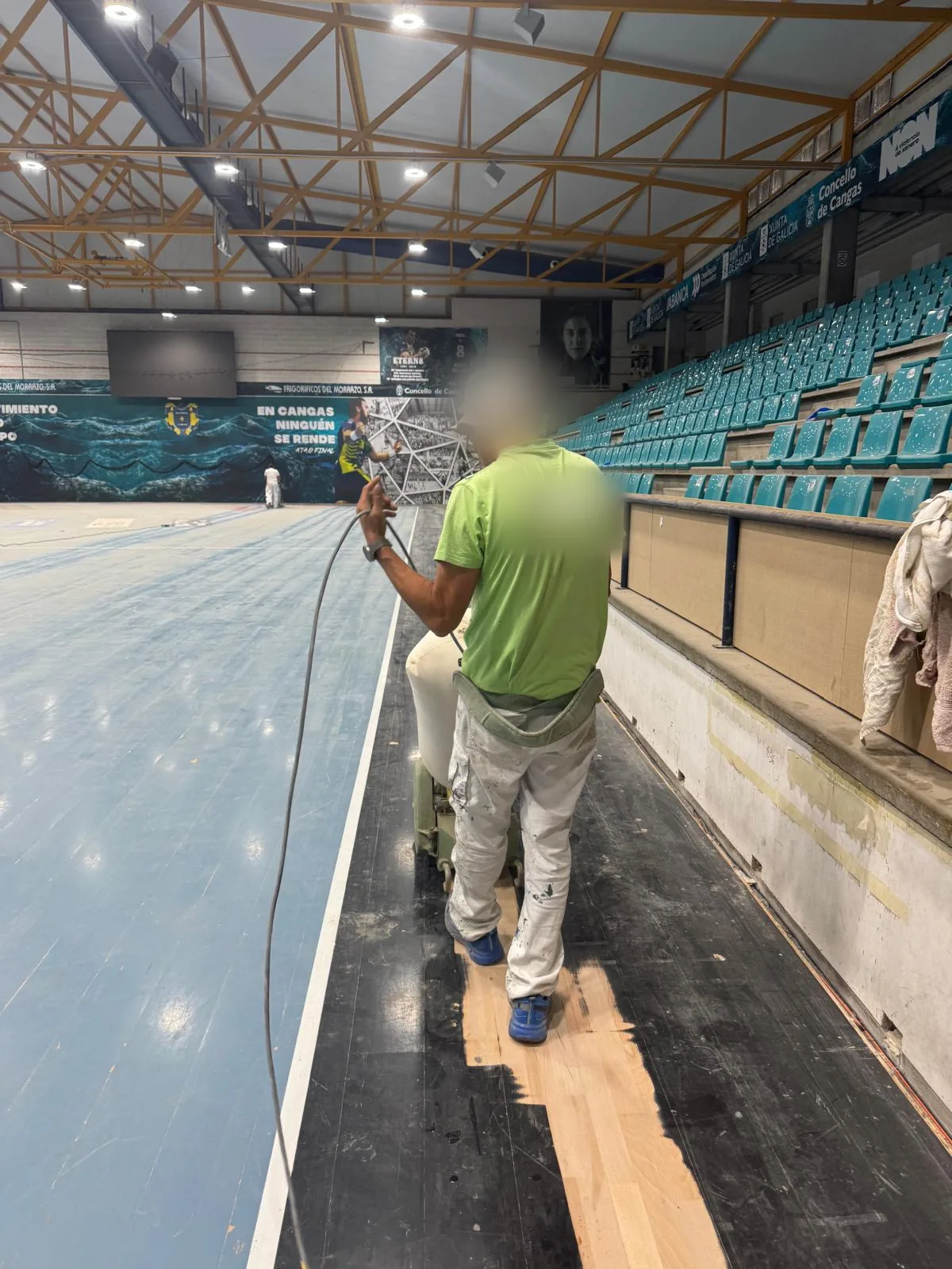 Operario aplicando el nuevo pavimento en la banda perimetral de la pista